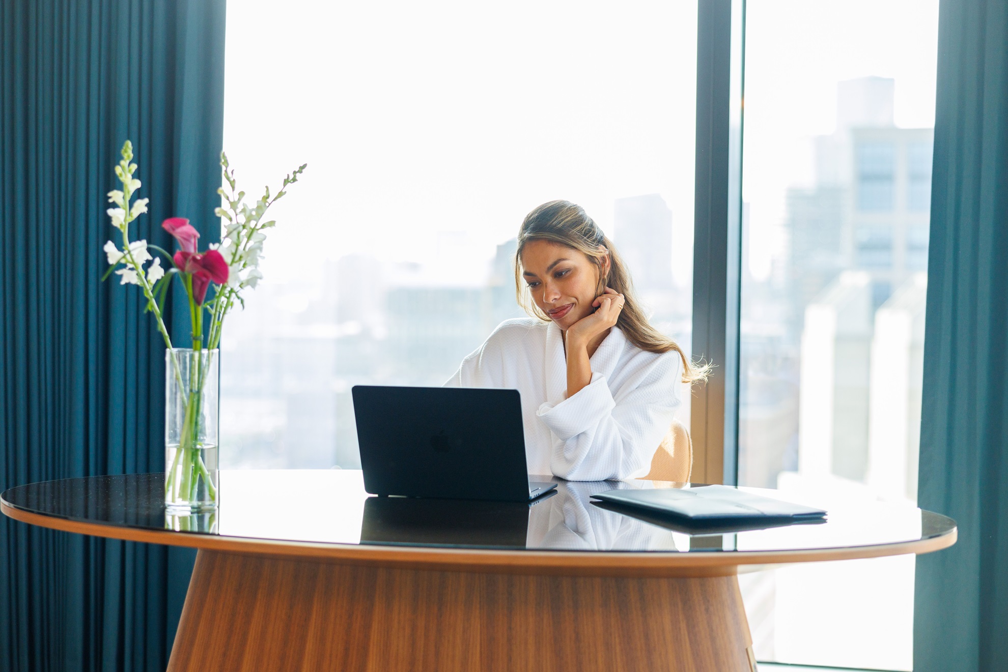 a woman at a desk looking at a laptop